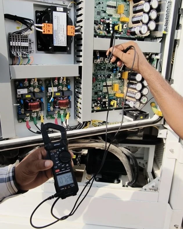 Urban Fix technician performing multimeter diagnostics on BESS control board